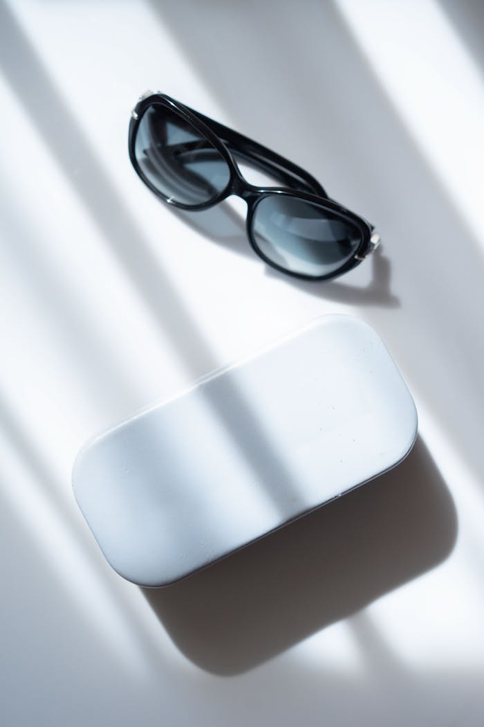 The Art of Drawing Readers In: Your attractive post title goes here Stylish black sunglasses on a white table casting dramatic shadows in sunlight.