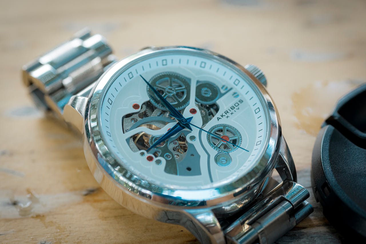 menu-04 Close-up of a luxury skeleton watch featuring a brushed metal band and intricate mechanics.