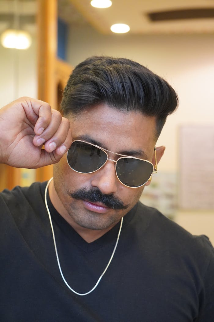 Crafting Captivating Headlines: Your awesome post title goes here Portrait of a confident man with a mustache wearing sunglasses and a necklace.